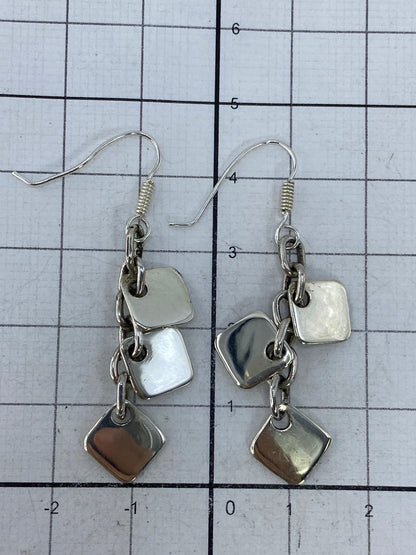 Los aretes sobre fondo blanco mostrando el patrón geométrico completo