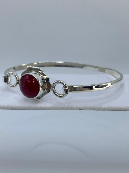 Brazalete de plata con coral rojo en muñeca, mostrando el diámetro interior de 6 cm y el ancho de banda