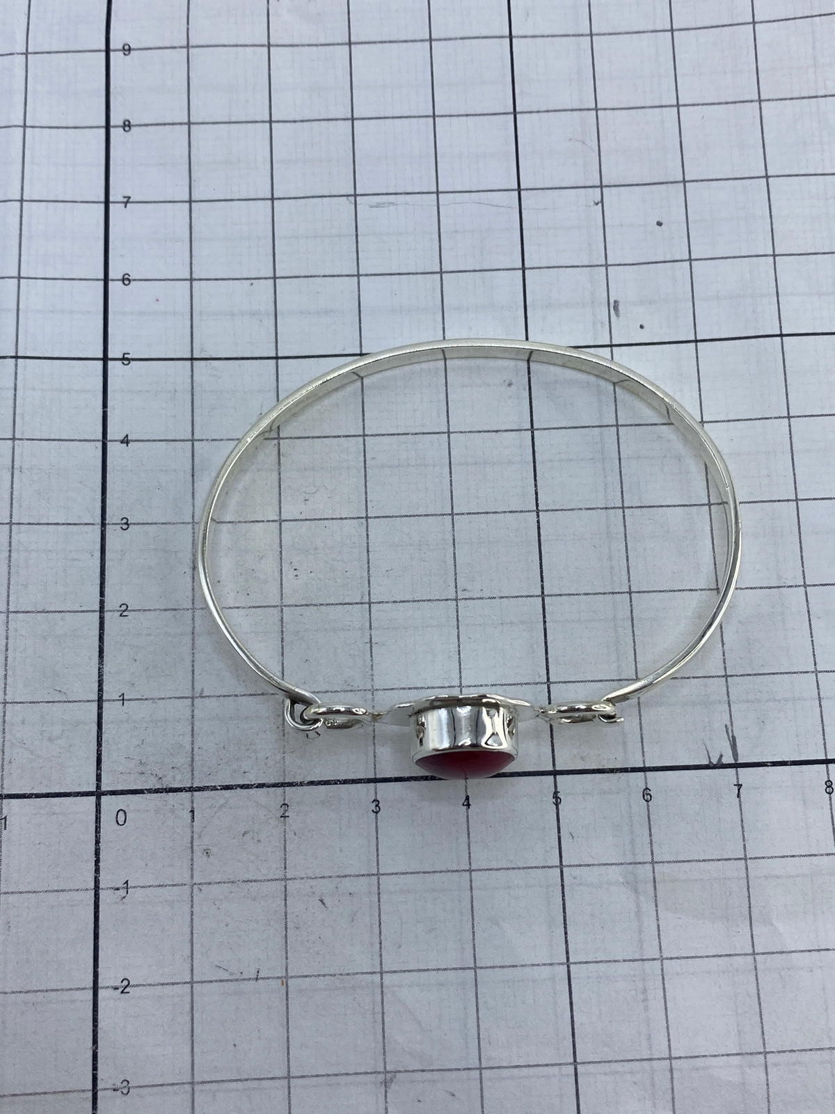 Brazalete plata con coral sobre escala de centímetros, verificando medidas (6 cm diámetro × 4.5 cm ancho)
