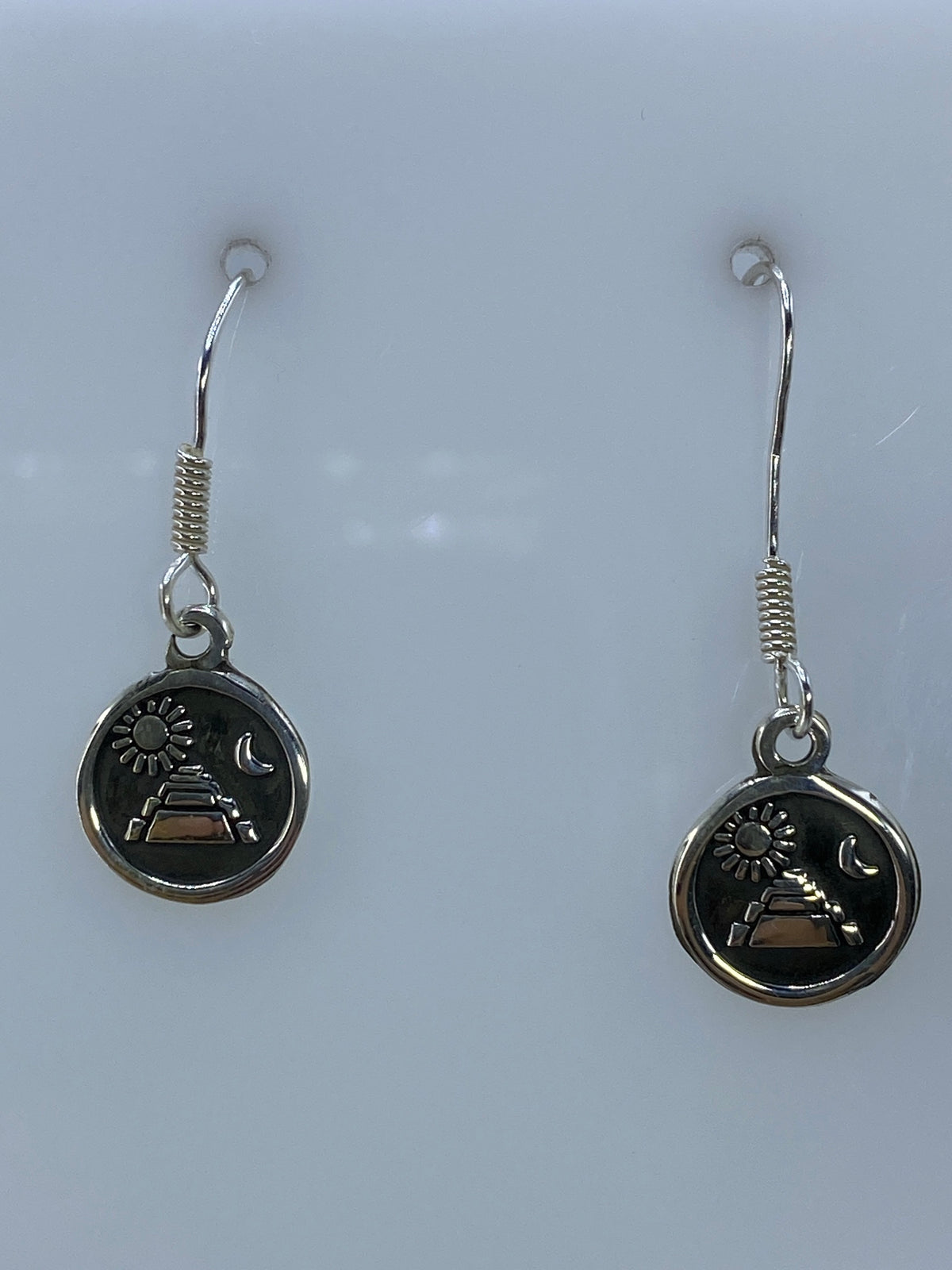 Par de aretes de plata repujados con motivo prehispánico de pirámide, sol y luna