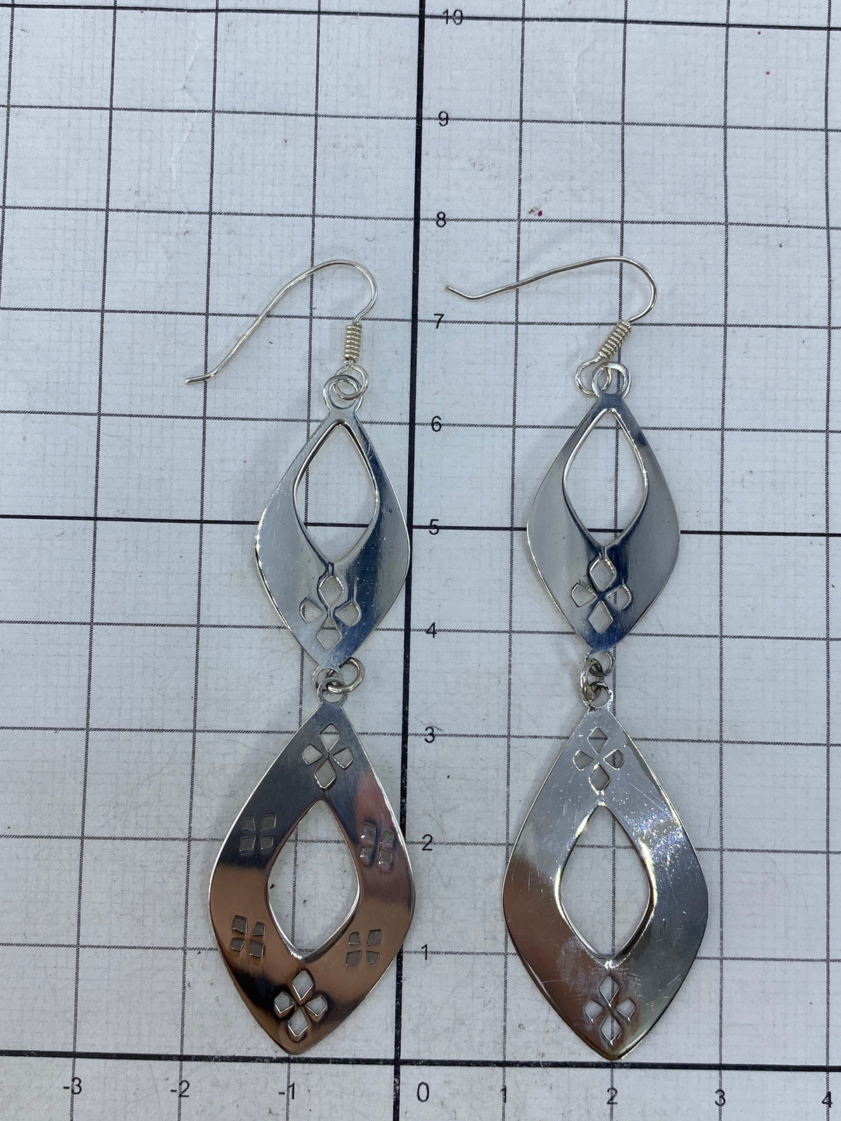 Aretes sobre fondo blanco mostrando la patina de oxidación controlada en los detalles
