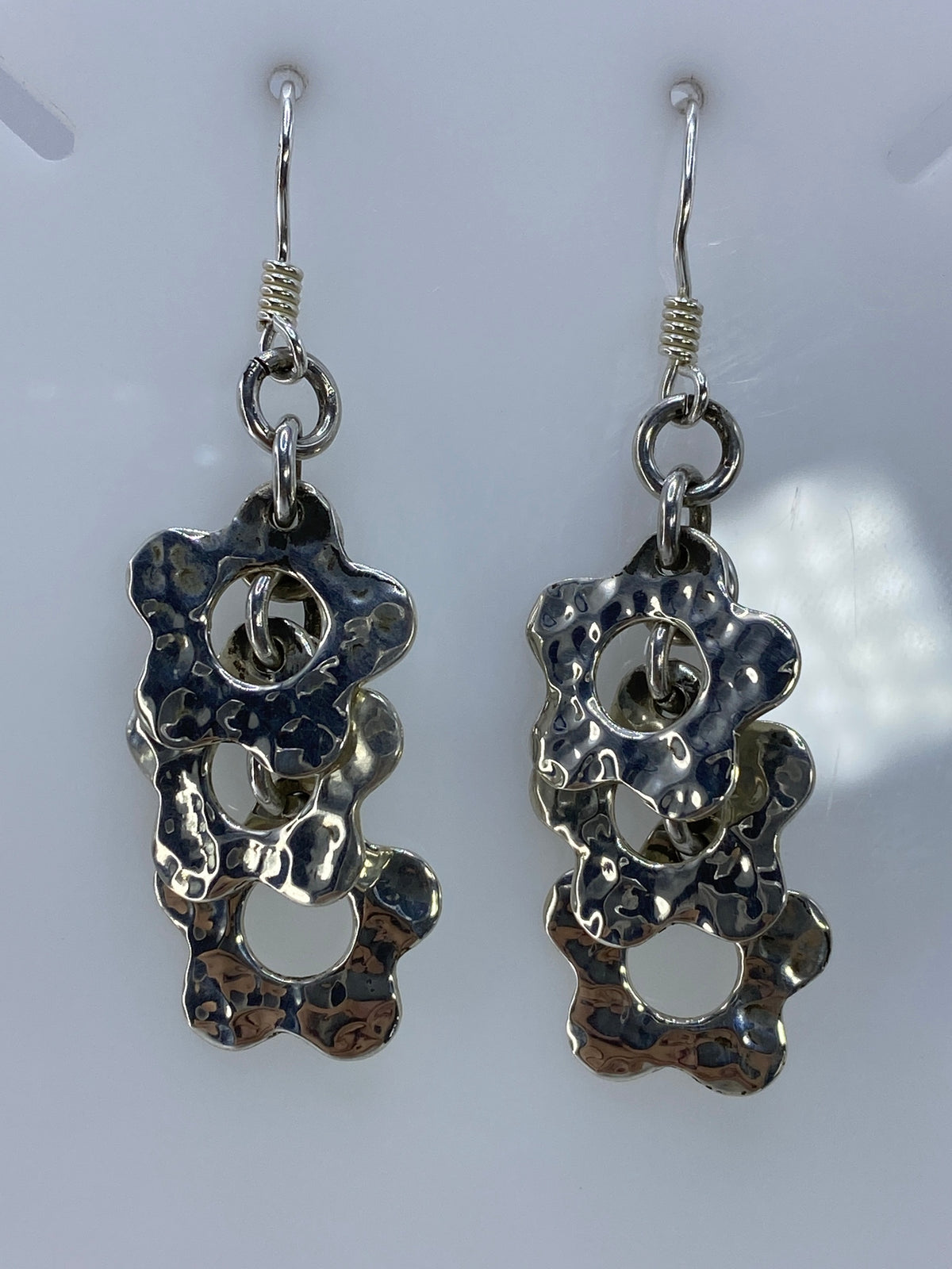 Aretes de plata calado vistos de frente mostrando la geometría tallada