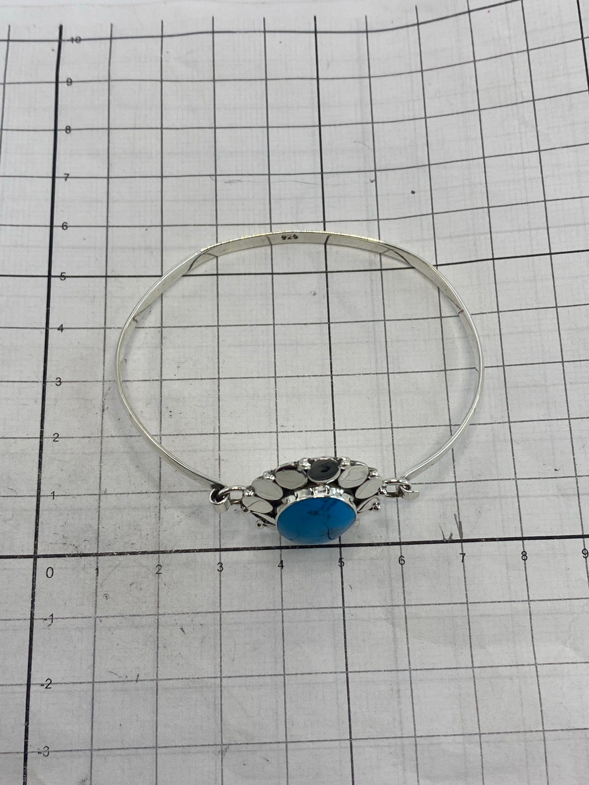 Brazalete de plata sobre fondo blanco mostrando el Quinto 925