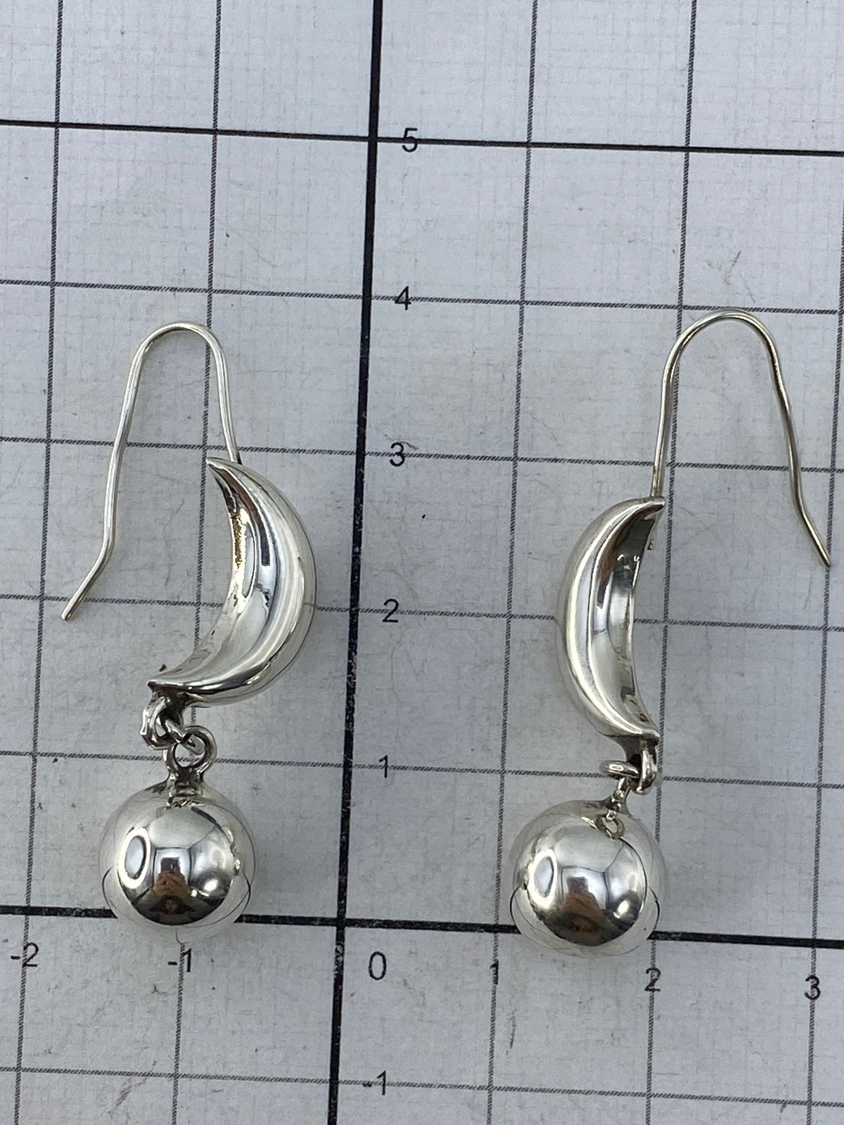 Aretes en la mano mostrando tamaño real de 4 cm y ligereza
