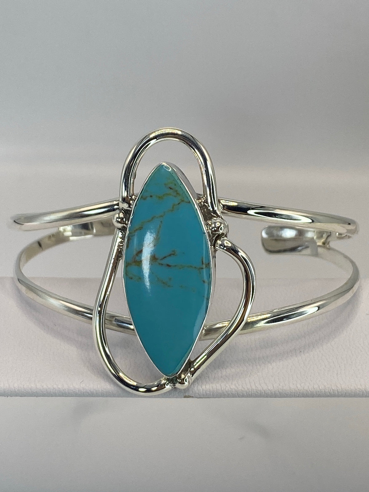 Brazalete rígido de plata 950 con turquesa azul cielo, vista frontal sobre fondo gris
