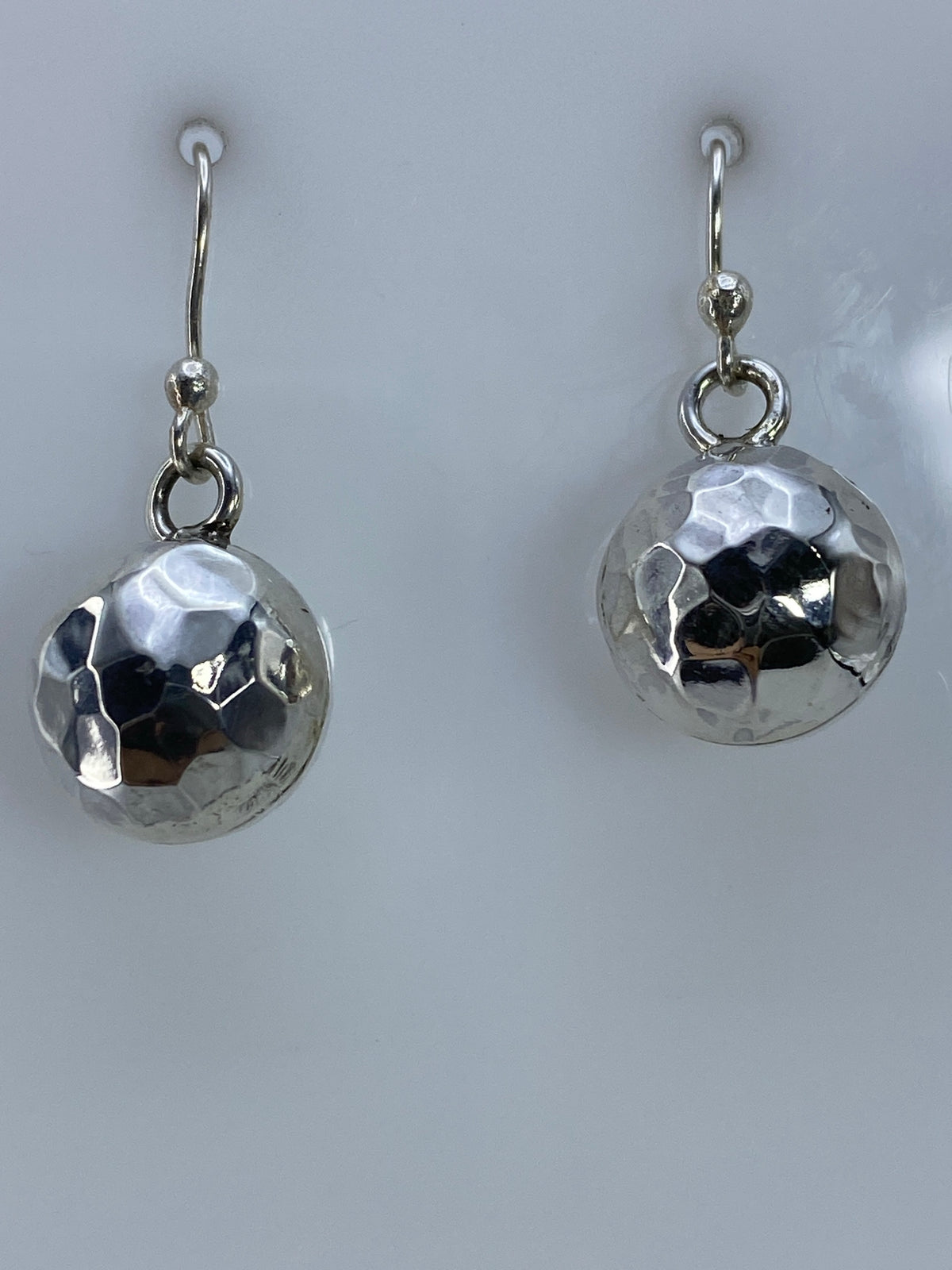 Par de aretes de plata con esfera facetada brillante colgando de ganchos de plata