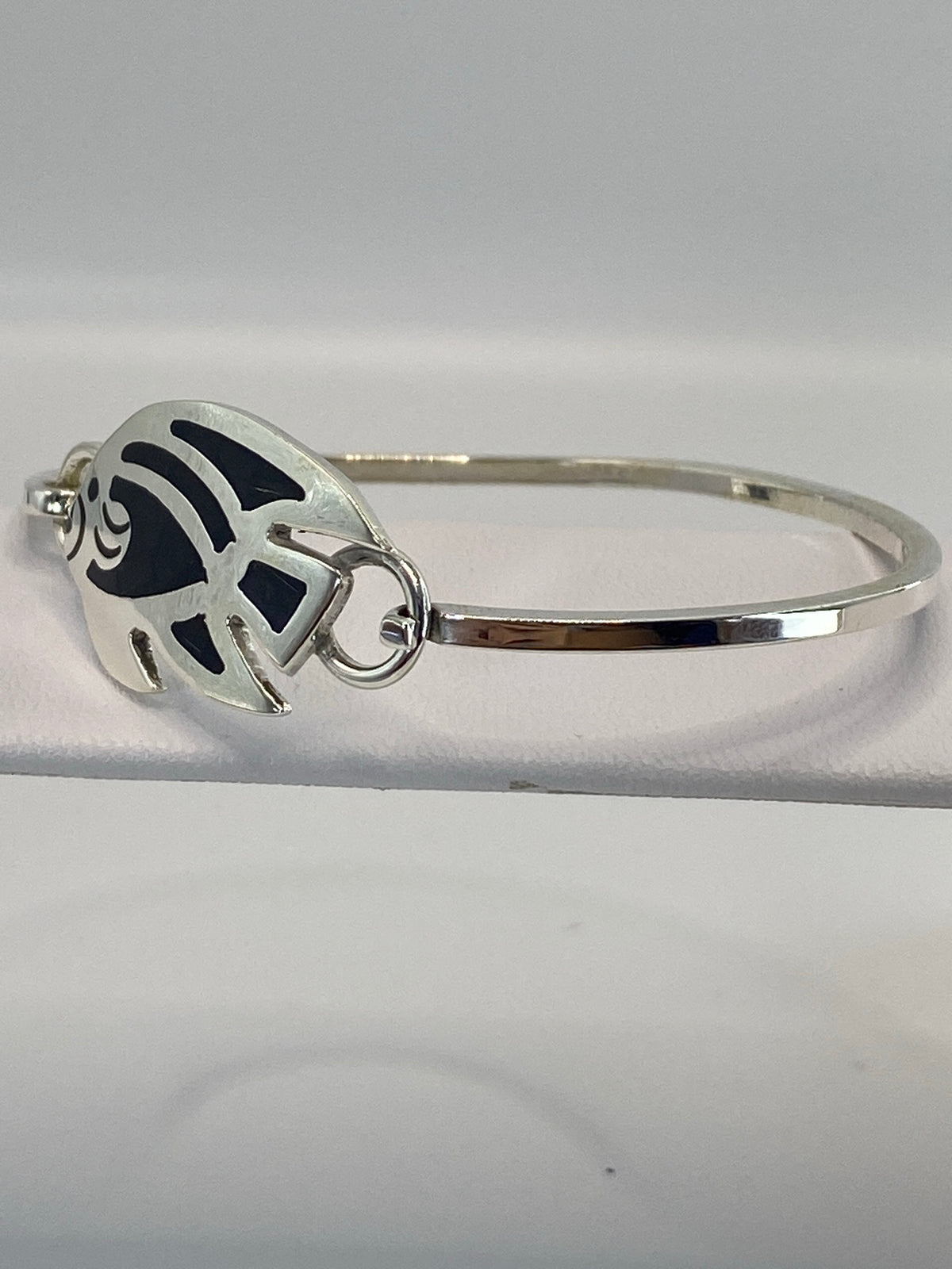 Brazalete cerrado mostrando el engaste de ónix negro y la banda ancha de plata
