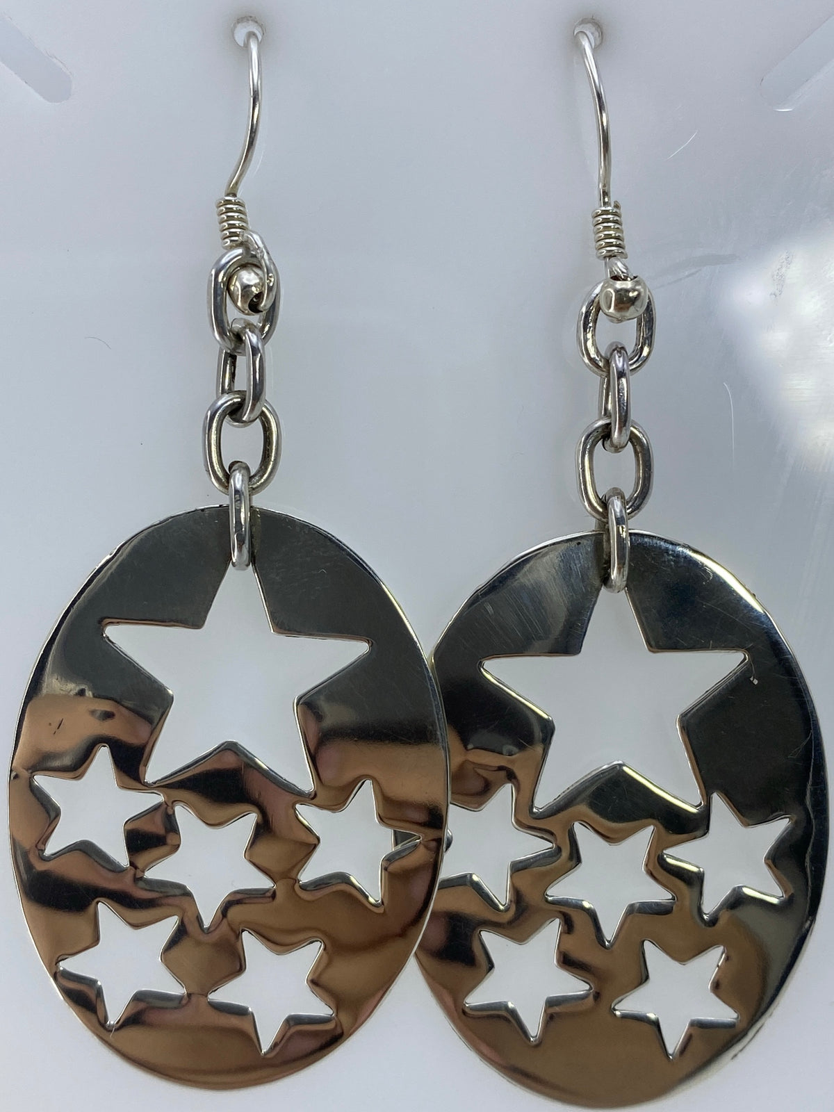 Aretes colgando mostrando el movimiento del diseño y cómo juega la luz en el calado