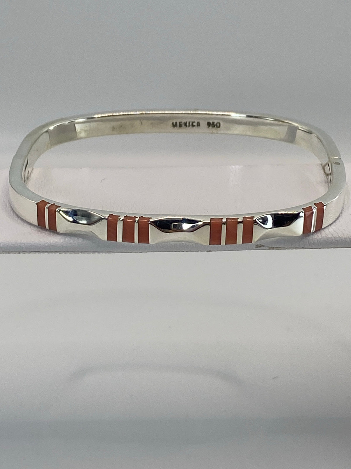 Brazalete rígido de plata 950 con coral rosa engastado, visto desde arriba en forma ovalada