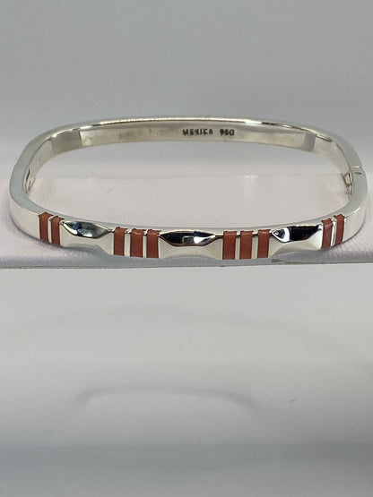 Brazalete rígido de plata 950 con coral rosa engastado, visto desde arriba en forma ovalada