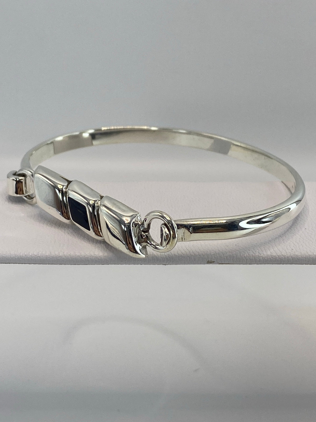 Brazalete en la muñeca de una mujer mostrando el onix negro brillante y la plata pulida