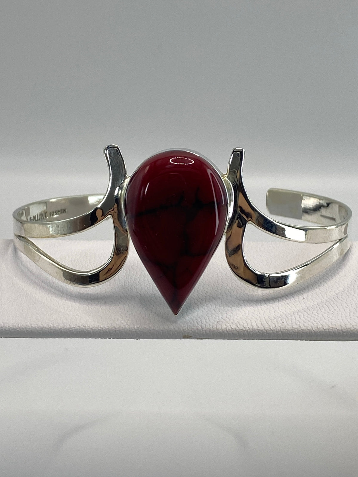 Brazalete de plata rígido con coral rojo engastado, vista frontal sobre fondo blanco
