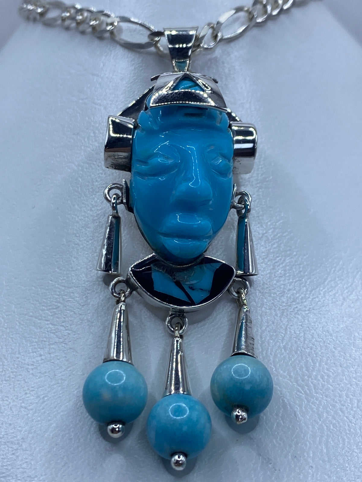 Detalle frontal de la figura prehispánica y el engaste de turquesa azul en plata