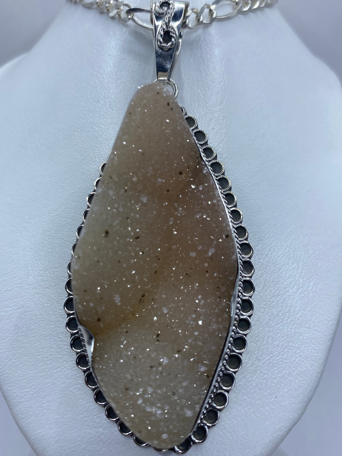 Dije de plata 950 con cuarzo rosa pulido, montado en orilla ornamental de Taxco