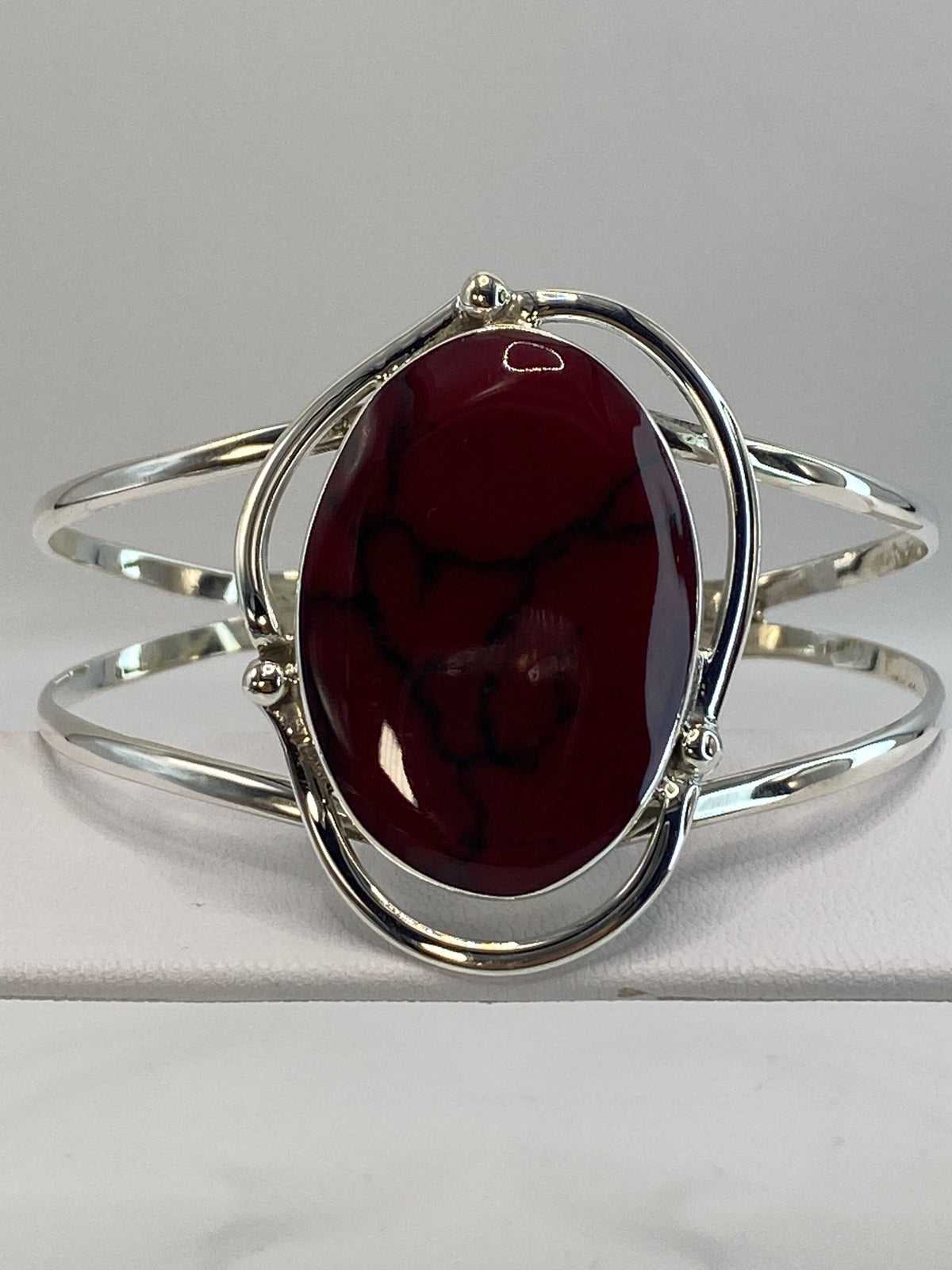 Brazalete de plata rígido con coral rojo engastado, visto de frente