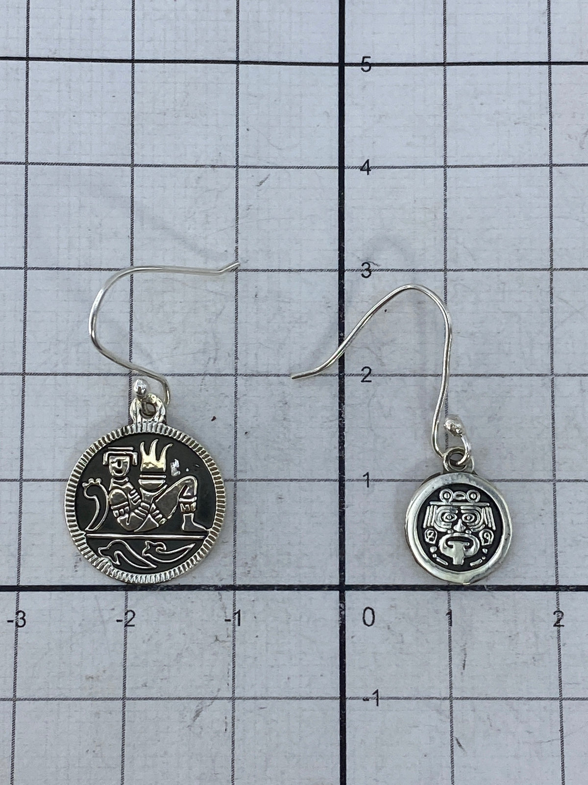 Par de aretes de plata sobre fondo blanco mostrando el Quinto 925 en el reverso