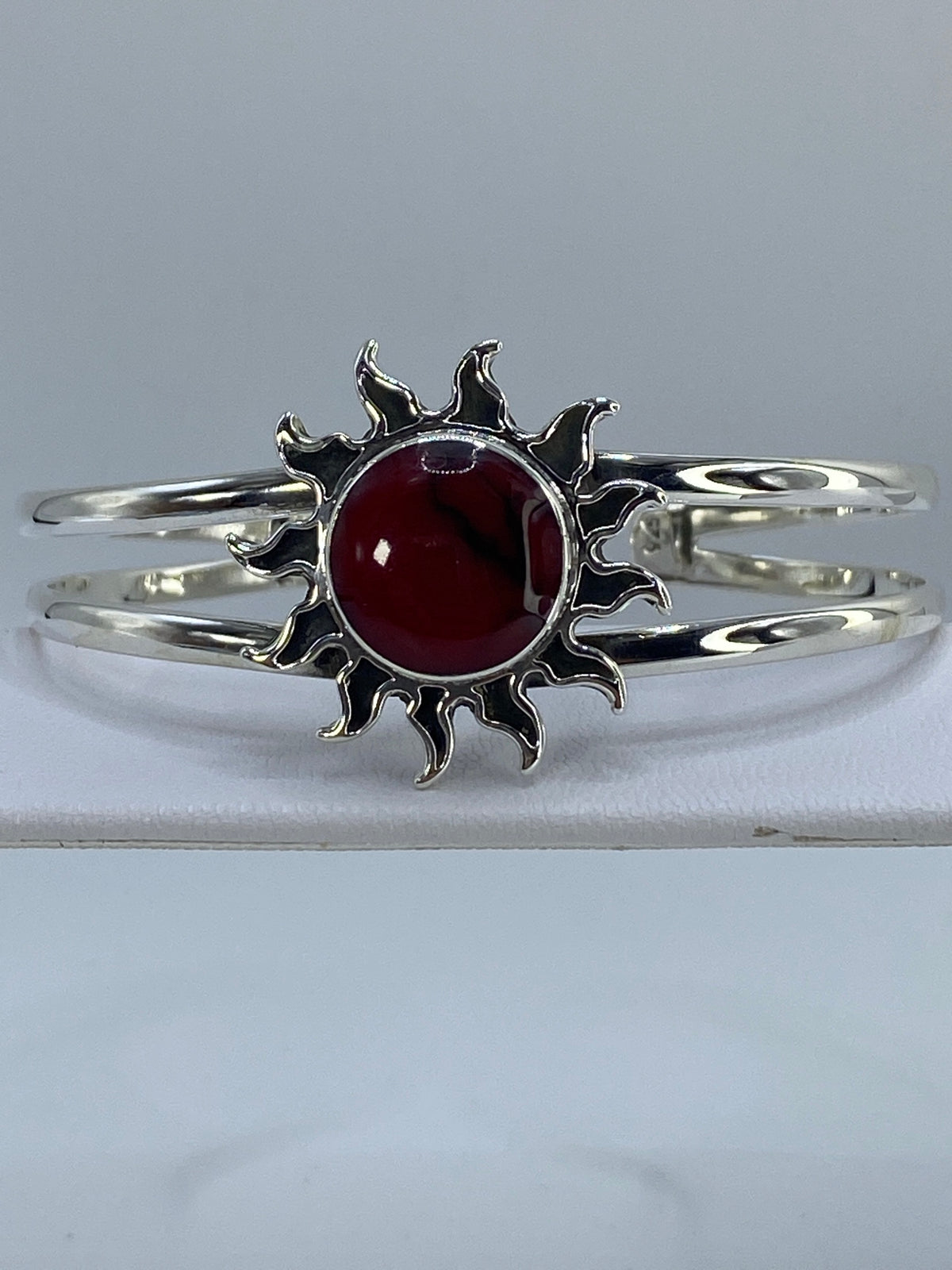 Brazalete de plata 925 con coral rojo engastado, visto de frente sobre fondo gris