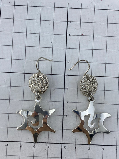 Aretes con Quinto 925 visible en el cierre de gancho de plata