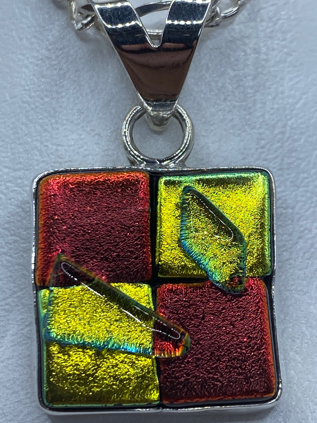 Dije de plata sobre escala de medida, 4 cm de largo