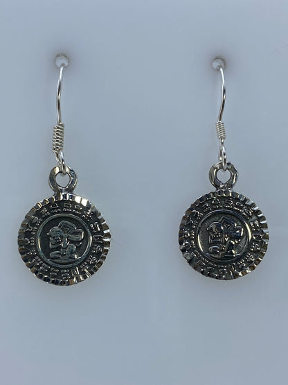 Par de aretes de plata 950 con repujado del Calendario Azteca colgando de gancho de plata