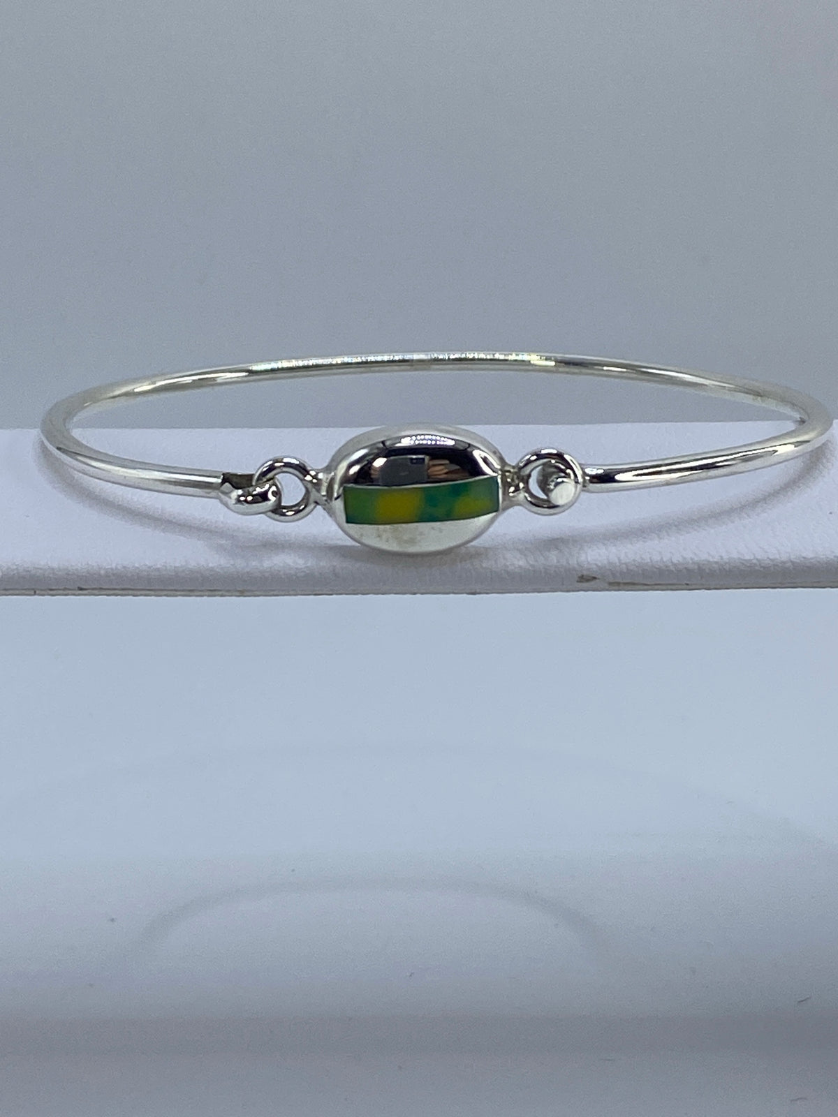 Brazalete rígido de plata 925 con turquesa africana multicolor en la mano