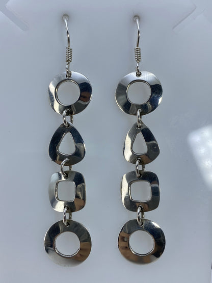Vista frontal de los aretes colgantes con detalle del corte preciso de cada forma