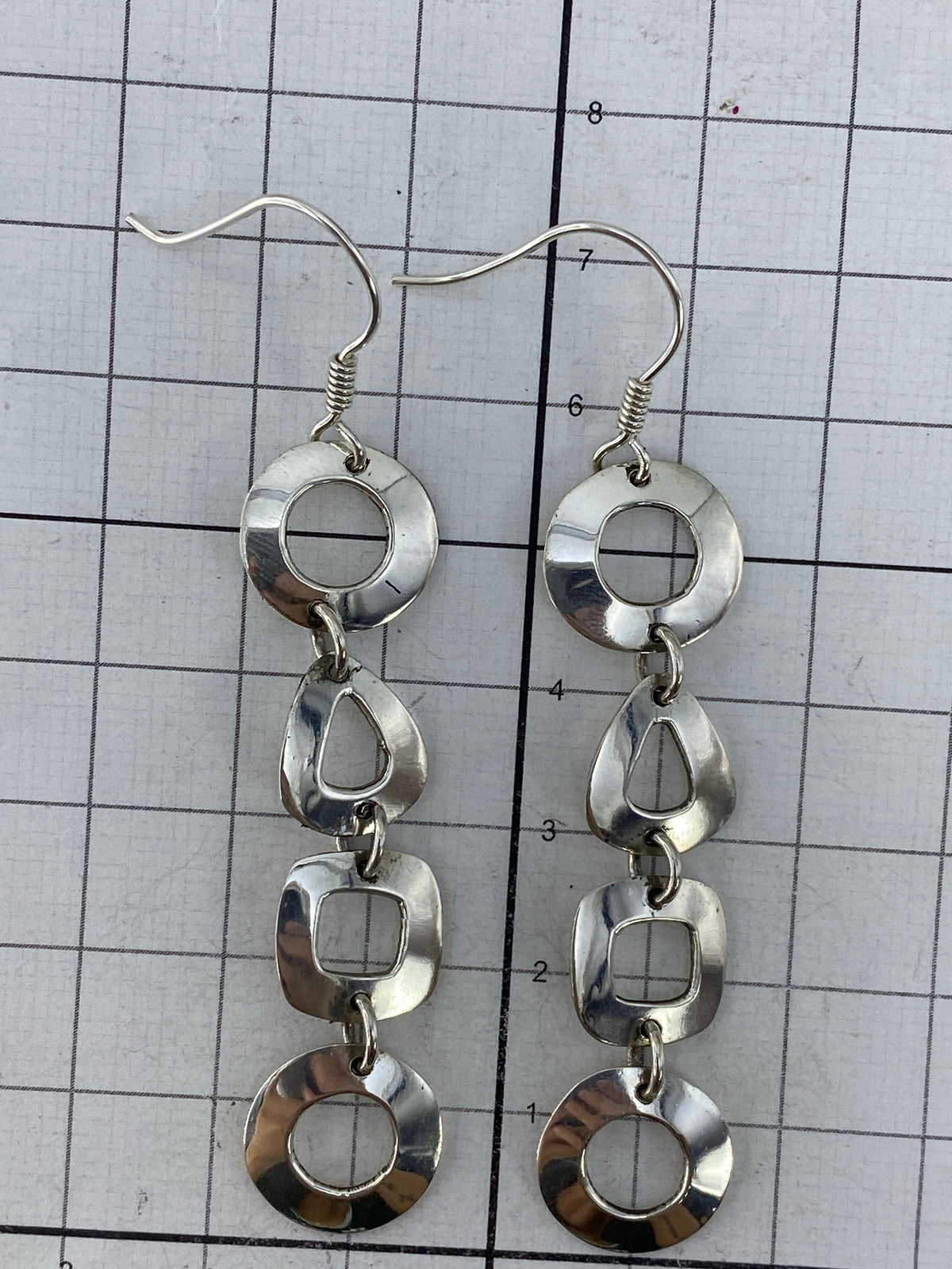 Aretes sobre fondo blanco con el Quinto 950 visible en el eslabón central