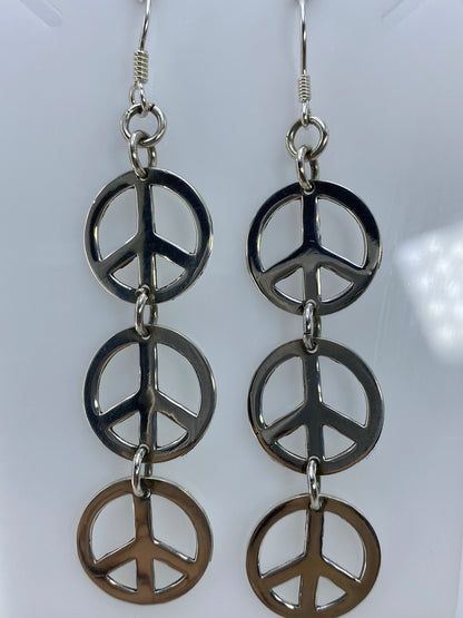 Aretes de paz sobre regla mostrando largo de 8.2 cm desde gancho