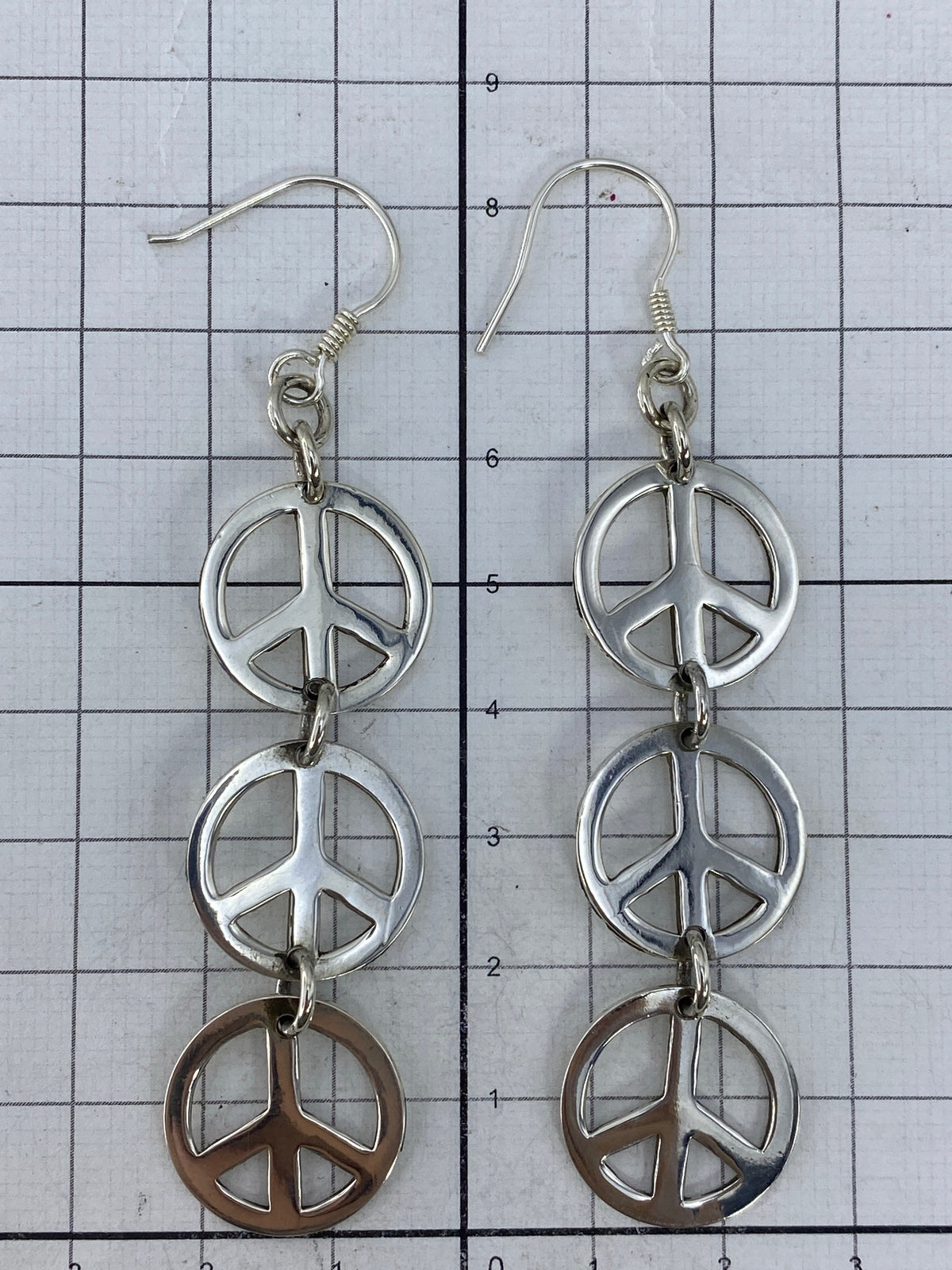 Aretes de plata símbolo de paz con Quinto visible en la base