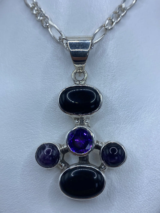 Dije cruz de plata 925 con ónix negro, amatista morada y circonia engastados, colgante sobre fondo blanco
