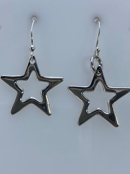 Par de aretes de plata con diseño de estrella calada, colgando del gancho
