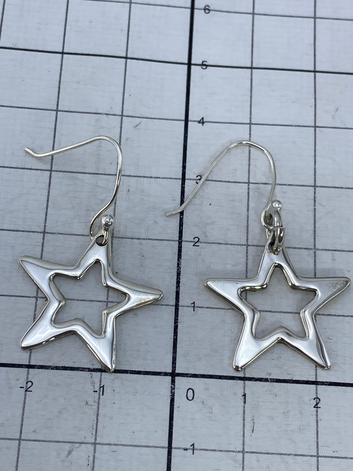 Aretes sobre fondo blanco con marca 925 visible en el gancho