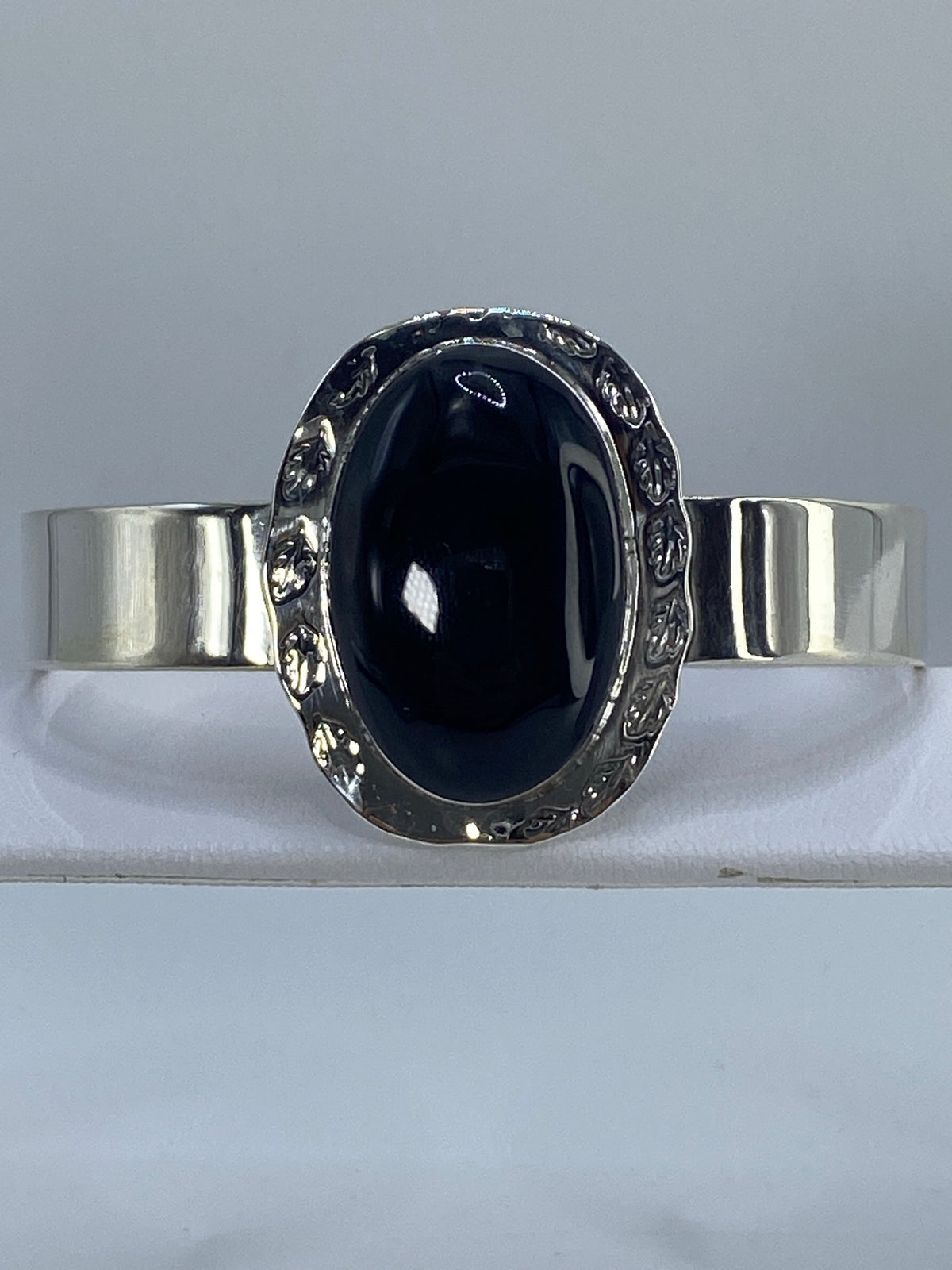 Brazalete plata 925 con onix negro engastado, frente, sobre fondo gris