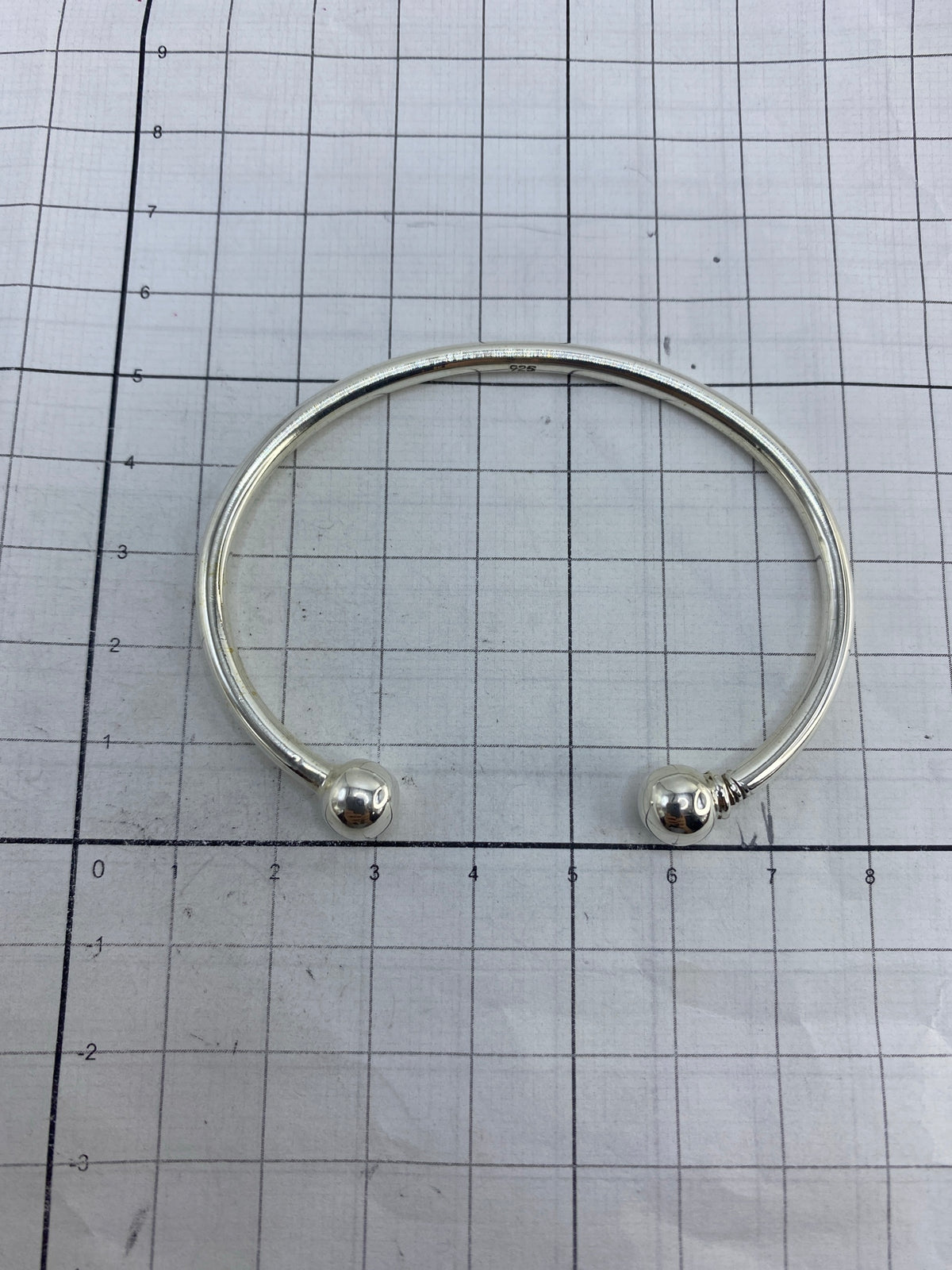 Brazalete sobre fondo blanco revelando el Quinto 925 grabado en la plata