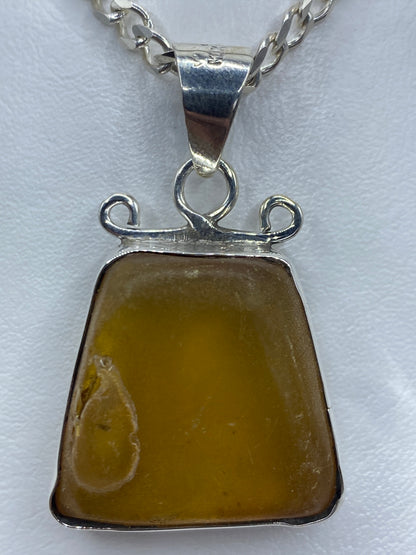 Detalle del ámbar natural amarillo en engaste de plata a mano