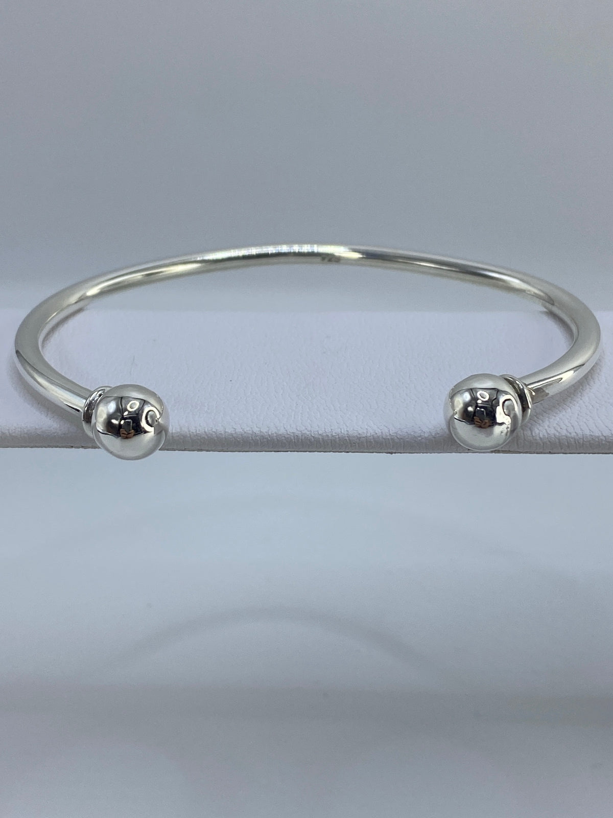 Vista lateral del brazalete de plata, detalle del volumen 3D de la técnica cartoneado