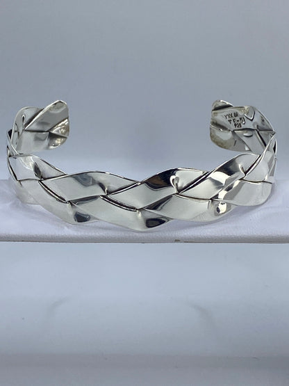 Brazalete rígido de plata con calado geométrico en muñeca de mujer