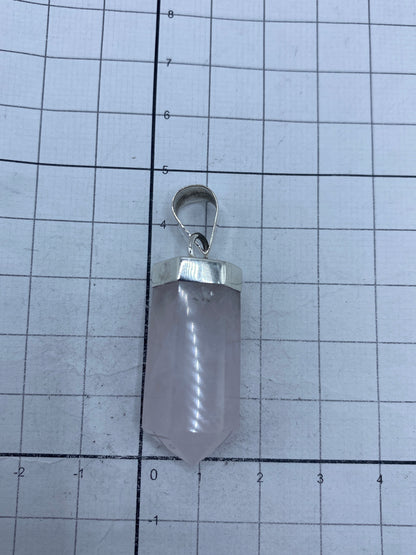 Dije de cuarzo rosa sobre regla, midiendo 4.6 cm de largo