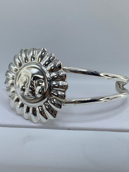 Vista frontal del brazalete mostrando el relieve profundo del Sol y la Luna grabados a mano