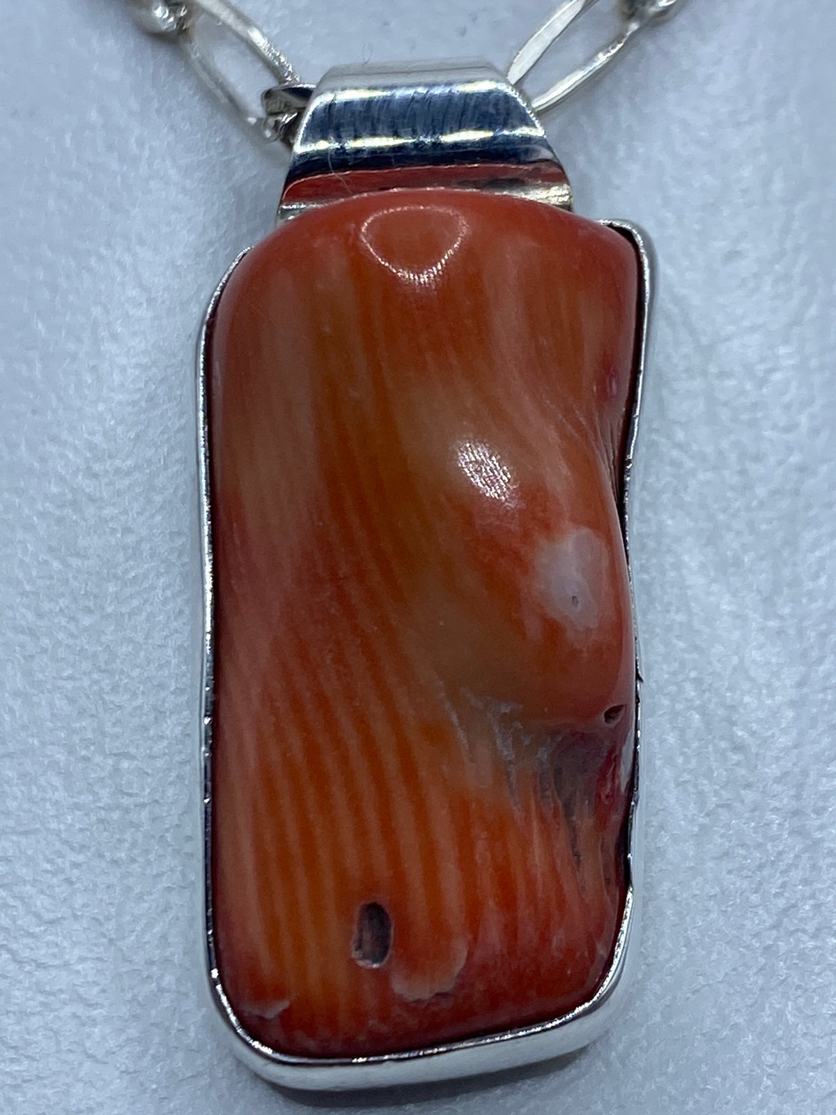 Detalle lateral del engaste a mano de la piedra en el dije de Taxco