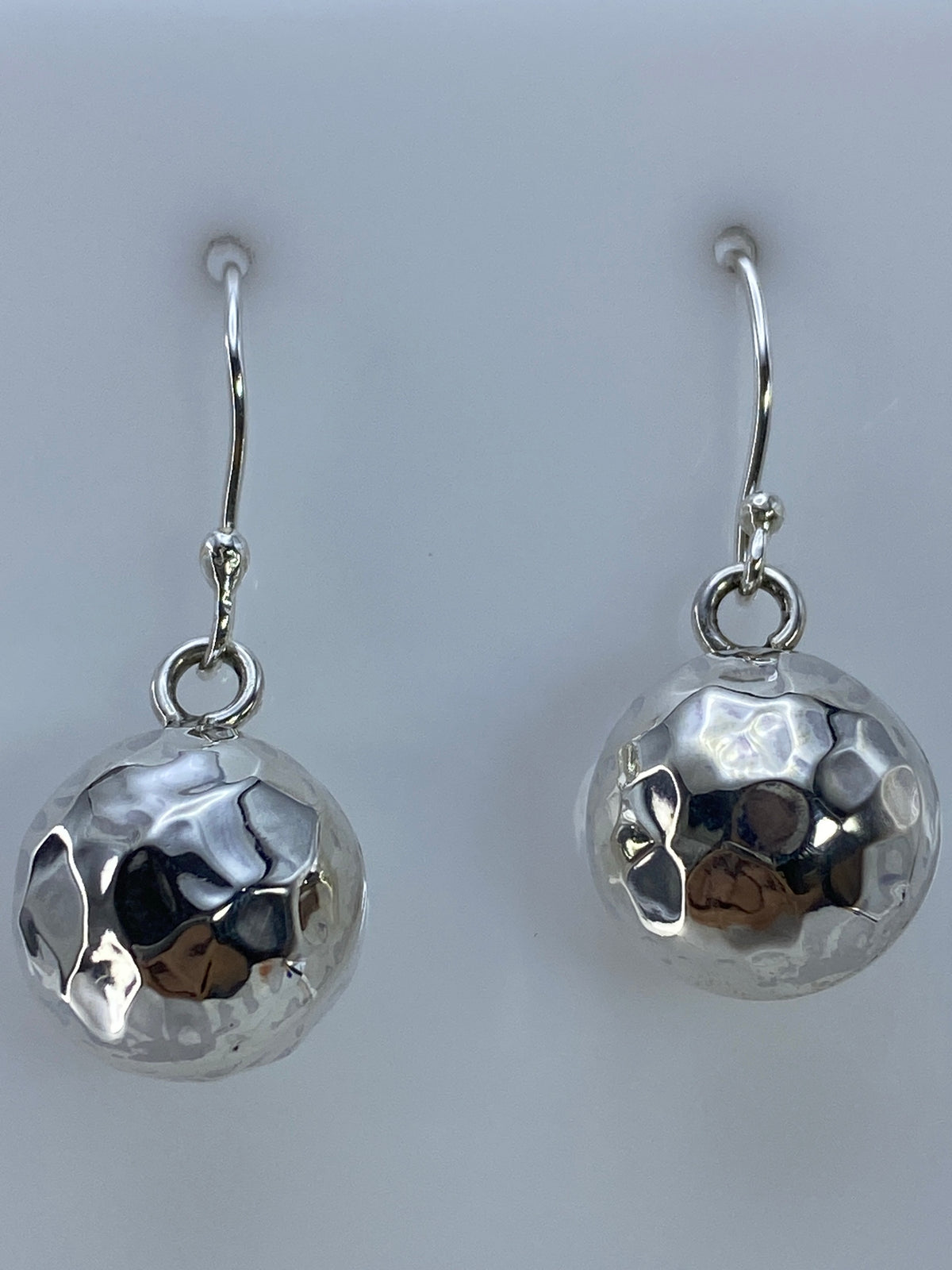 Aretes de cartoneado de Taxco en la mano mostrando el tamaño de 3 cm