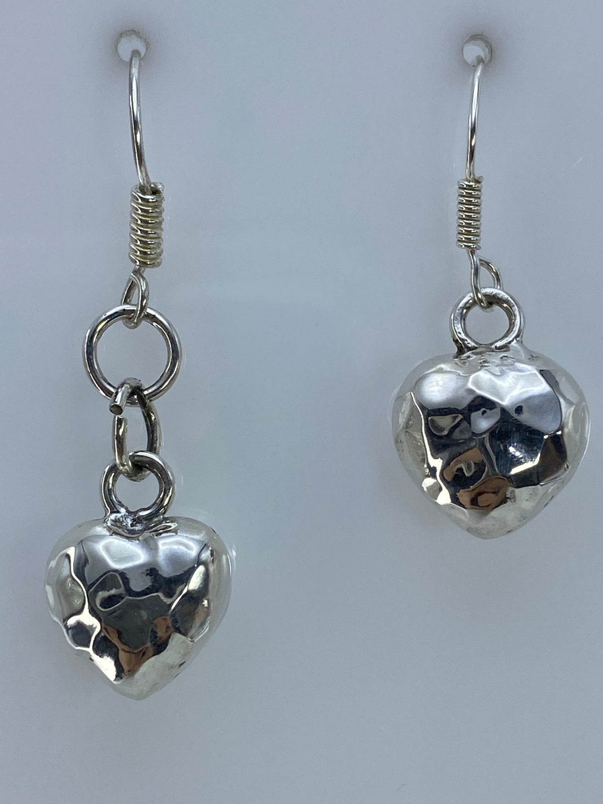 Par de aretes de plata con forma de corazón facetado, técnica cartoneado, colgando del gancho