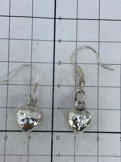 Par de aretes de corazón en plata 925 sobre fondo blanco, mostrando volumen y acabado
