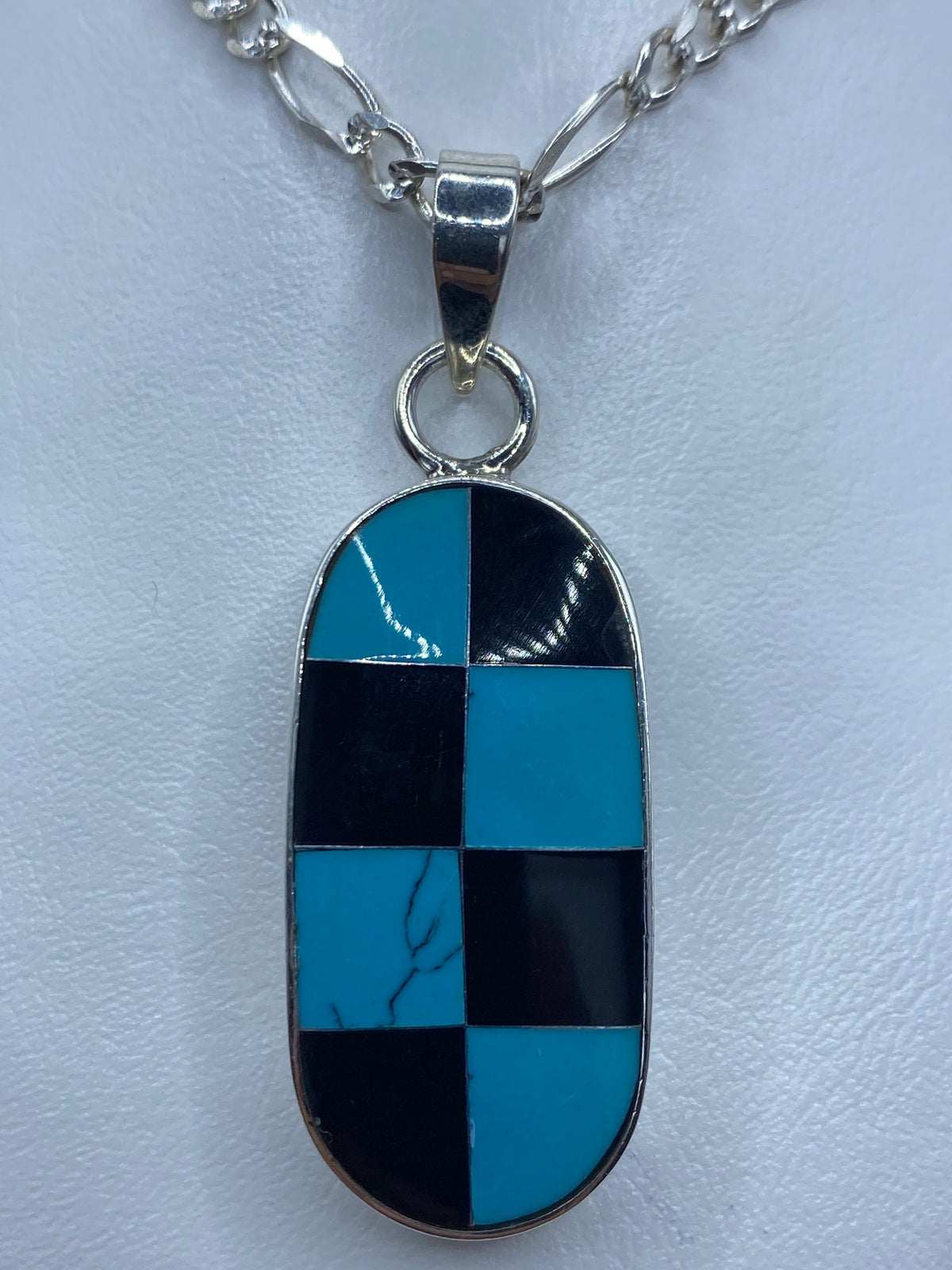 Dije de plata con cuadrícula geométrica de turquesa azul y ónix negro engastadas a mano
