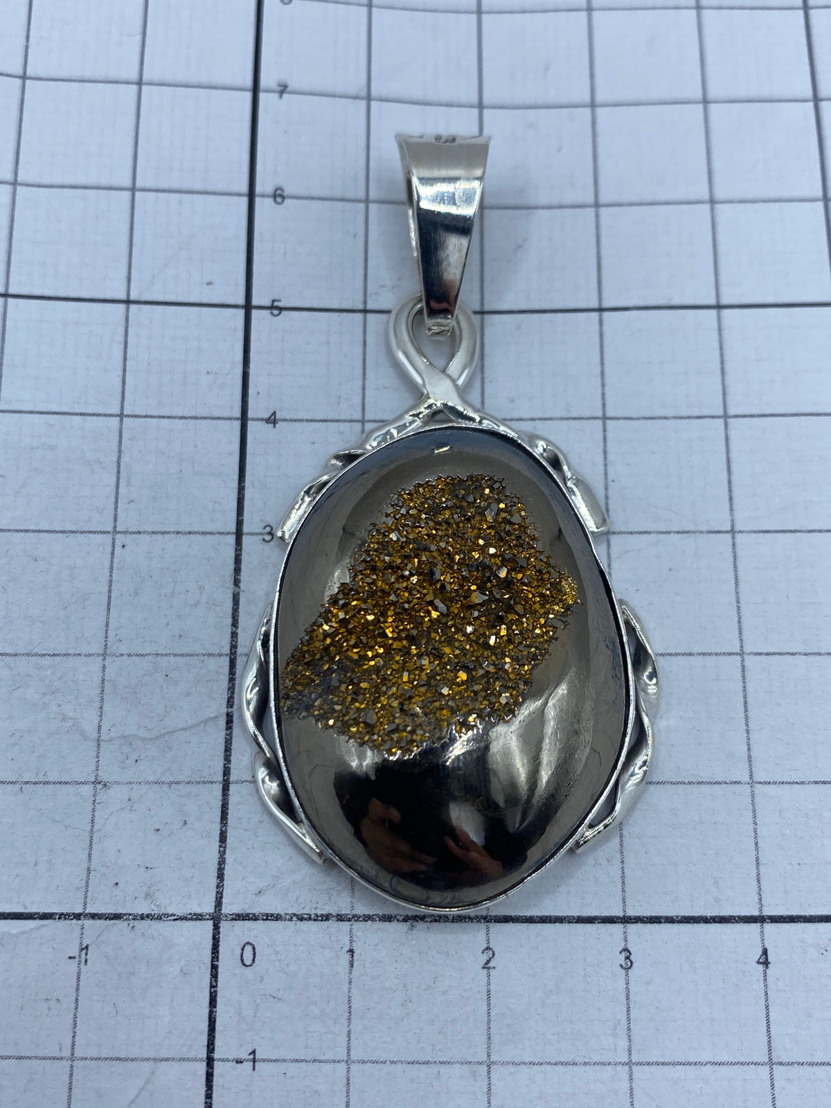 Dije sobre escala métrica: 6.4 × 3.1 cm, peso 18.7 gramos