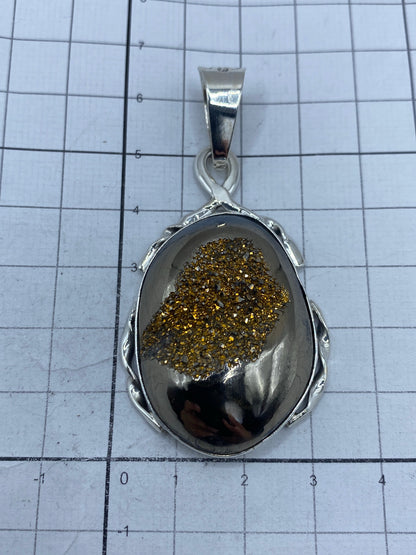 Dije sobre escala métrica: 6.4 × 3.1 cm, peso 18.7 gramos