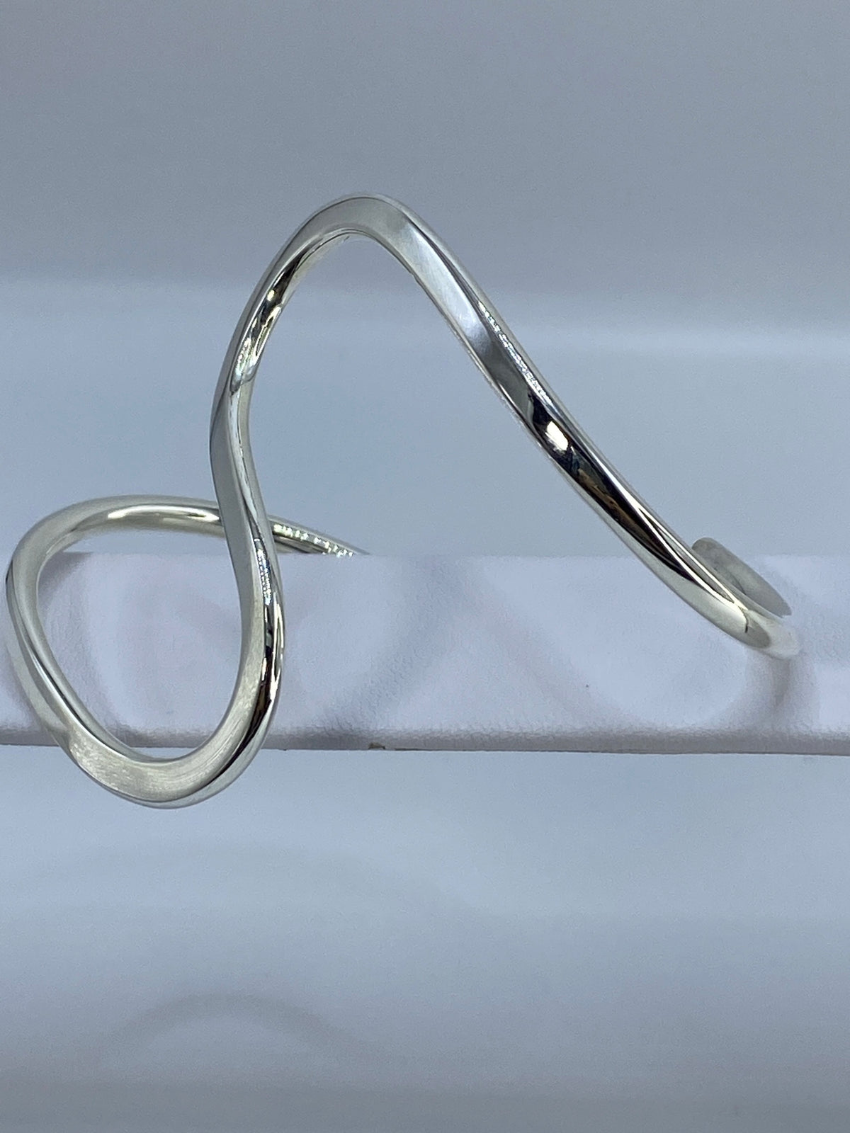 Brazalete rígido tipo esclava en plata 925, puesto en la muñeca
