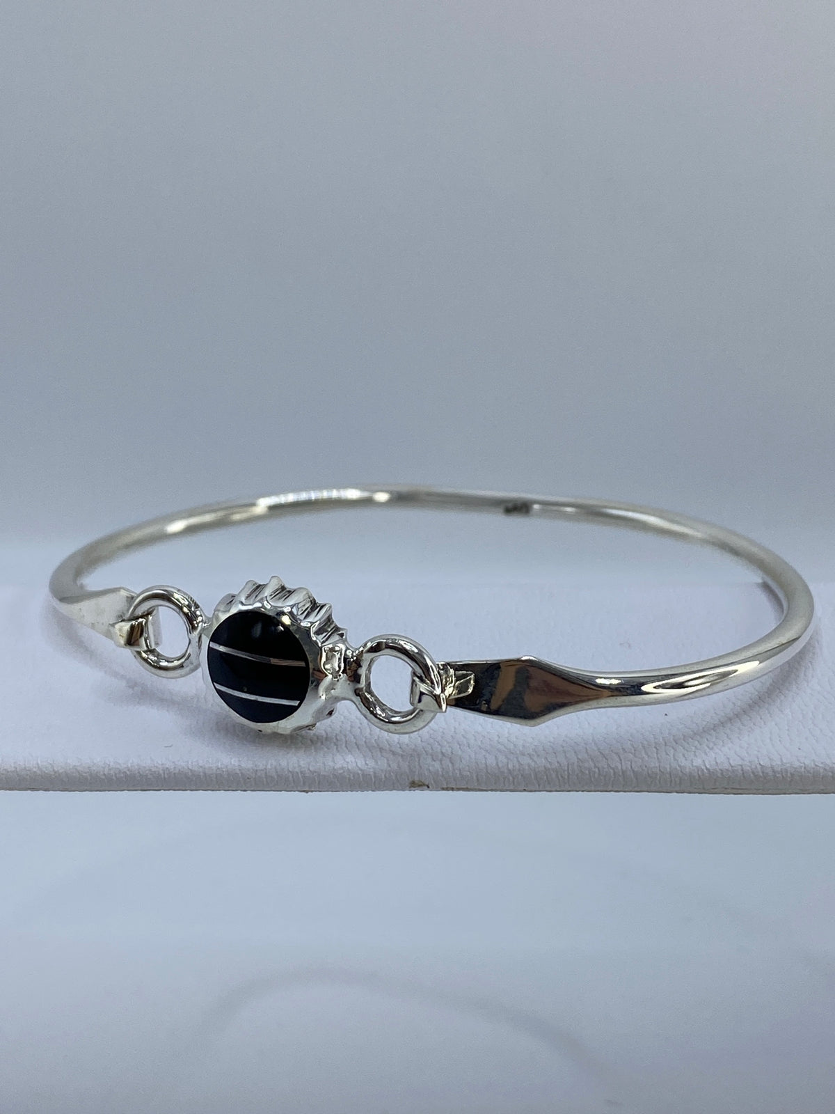 Brazalete de plata con ónix puesto en la muñeca, mostrando el diámetro interior de 6.7 cm