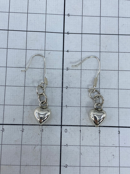 Par de aretes de corazón cartoneado en plata brillante, vista frontal