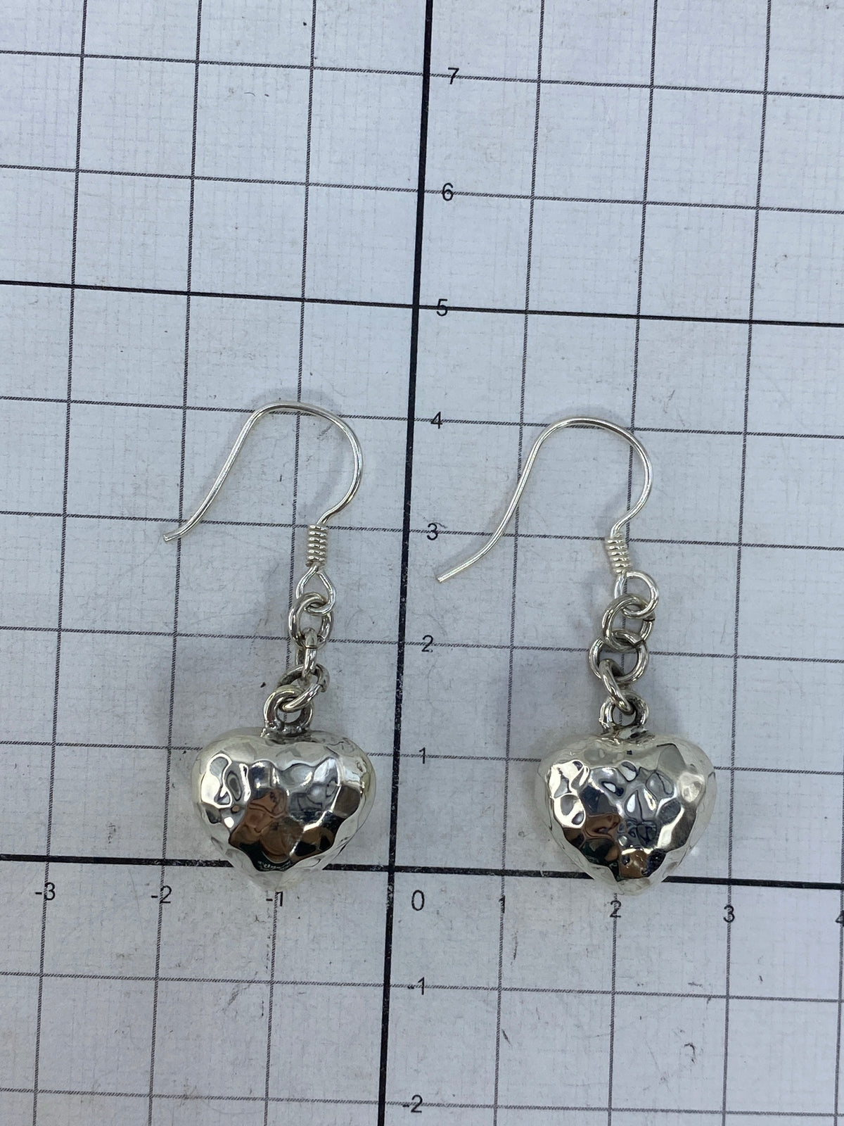 Aretes sobre fondo blanco con los ganchos de plata visibles